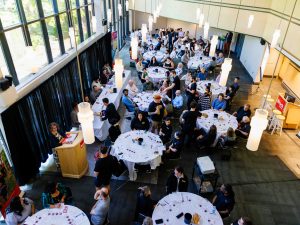 An overhead view of an event hall filled with tables and event attendees sampling wine.