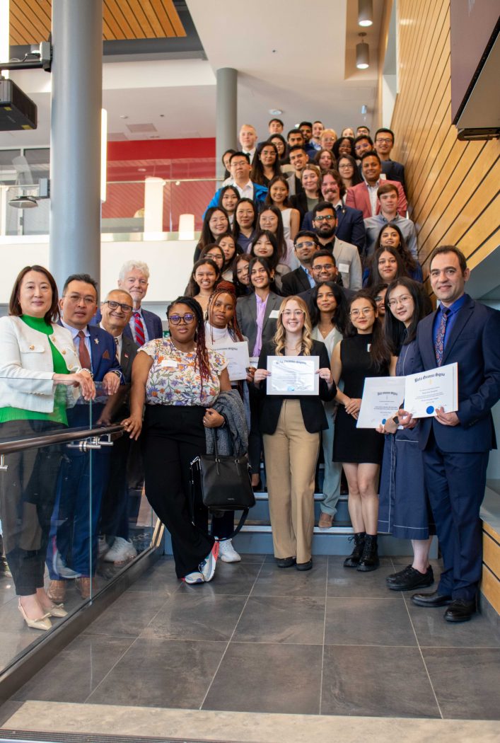 Goodman students and faculty fill a staircase in the Goodman Atrium for a group photo.