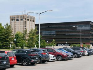 A parking lot filled with vehicles with the Campus Store in the background.