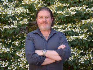 Gordon Hodson in front of a flowering tree on Brock’s main campus.