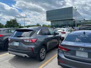 Cars parked in front of a glass building at Brock University.