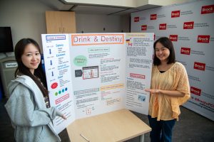 Two students with poster board showing a health presentation.