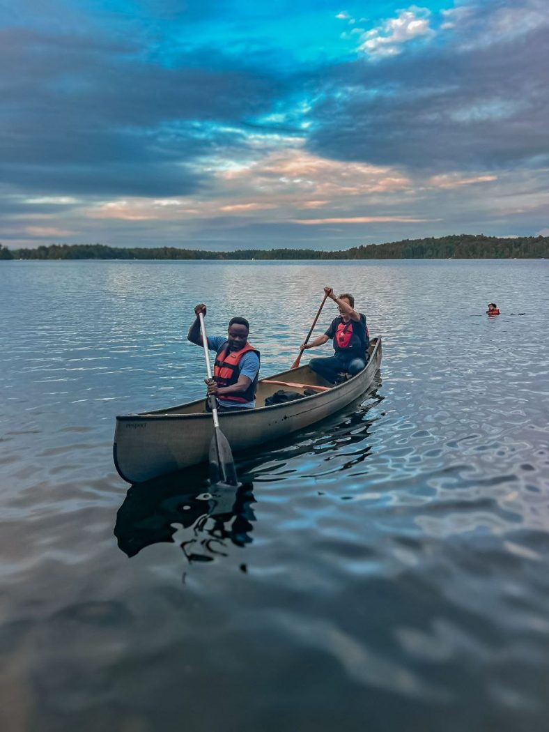 Two people paddle a canoe on a lake.