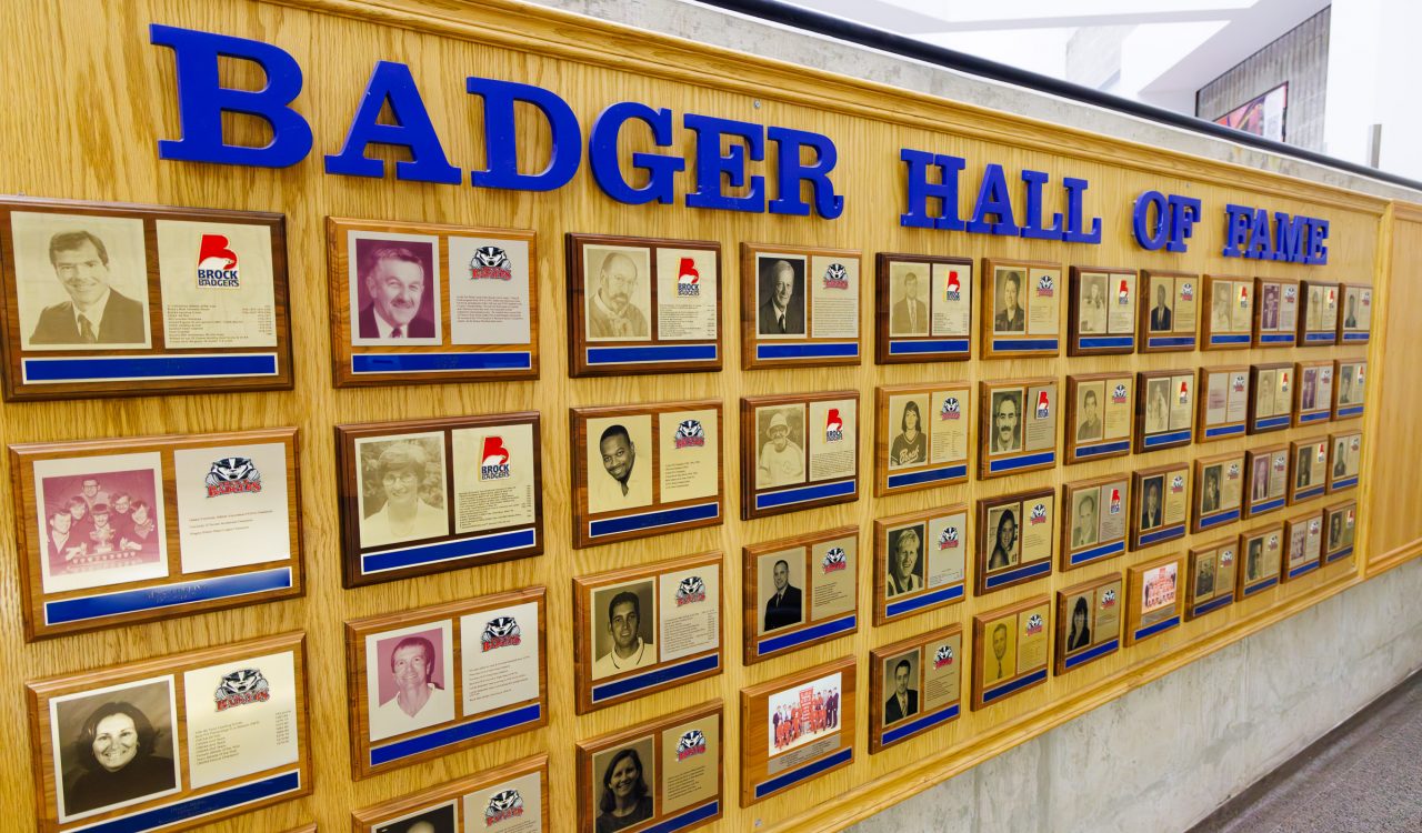 A wall displays plaques of athletes and builders for the Brock University varsity athletics Hall of Fame.