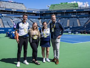 Four people stand together on the tennis court at Sobeys Stadium in Toronto.