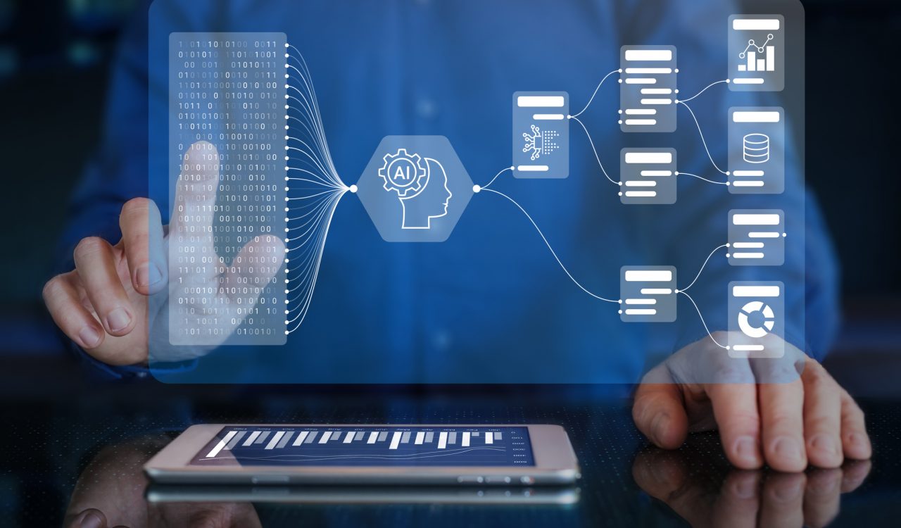 Close-up view of hands tapping on technology icons that float above a tablet on a desk.