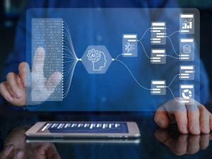 Close-up view of hands tapping on technology icons that float above a tablet on a desk.