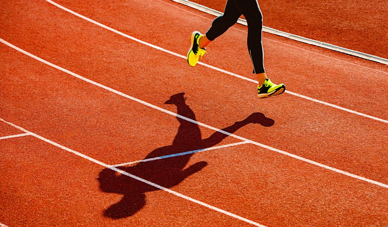 The legs and feet of a woman are seen running on a track.