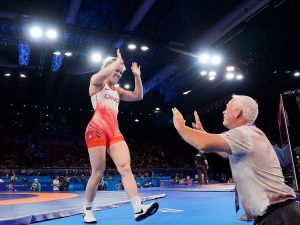 A woman high fives a man while walking off of a wrestling mat in Paris, France.