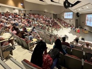 University students sit in a large lecture hall.