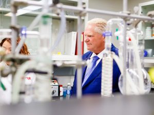 A man in a suit looks at equipment in a scientific laboratory.