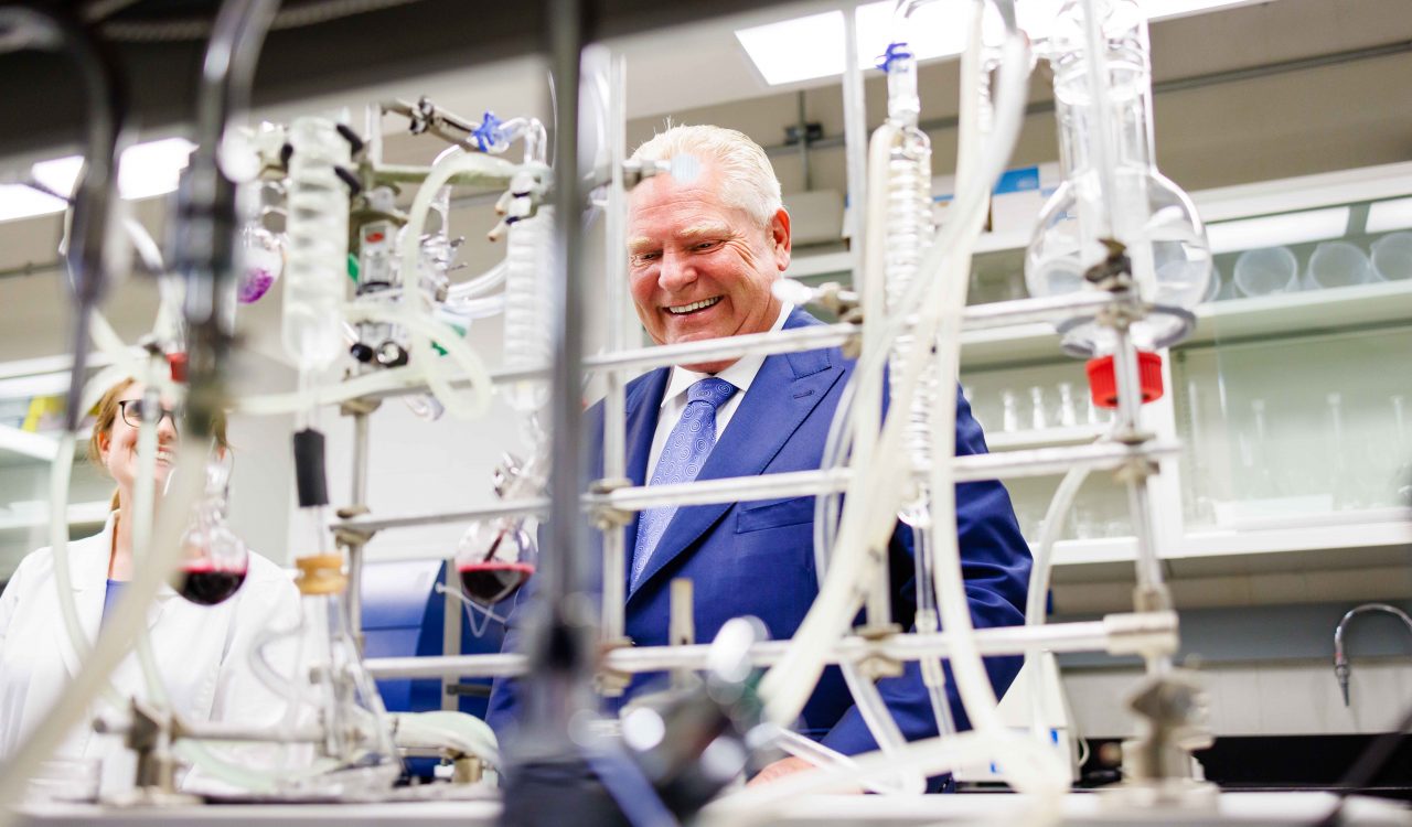 A man in a suit looks at equipment in a scientific laboratory.