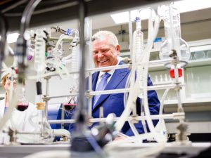 A man in a suit looks at equipment in a scientific laboratory.