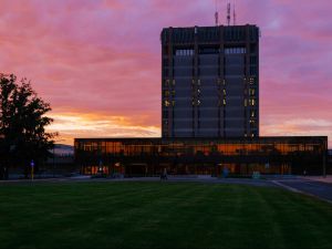 A silhouette of Brock University's Schmon Tower at dusk with a pink and orange sky in the background.