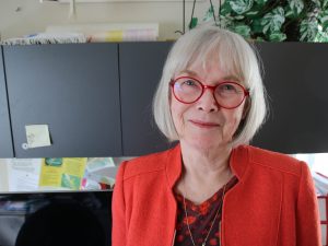 Professor Susan Drake stands in an office.