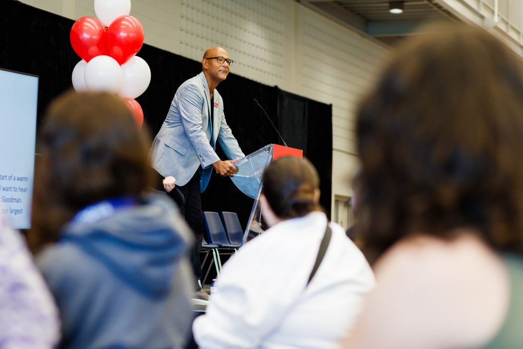 A man stands at a podium addressing a crowd.