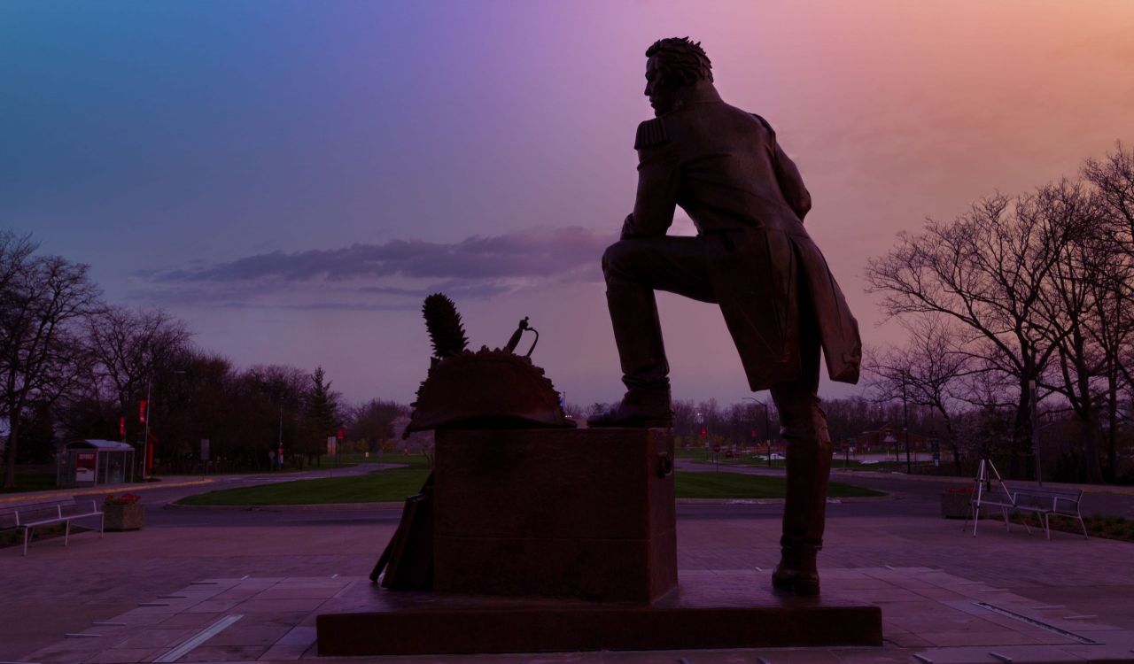 Silhouette of a statue of a man at sunrise.