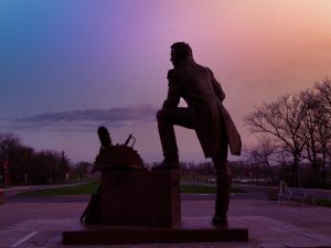 Silhouette of a statue of a man at sunrise.