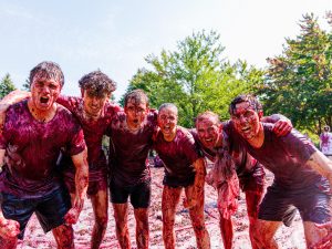 A group of six students yell and scream in celebration during Brock University’s Grape Stomp.