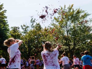 Female students throw grapes into the sky during Brock University’s annual grape stomp.