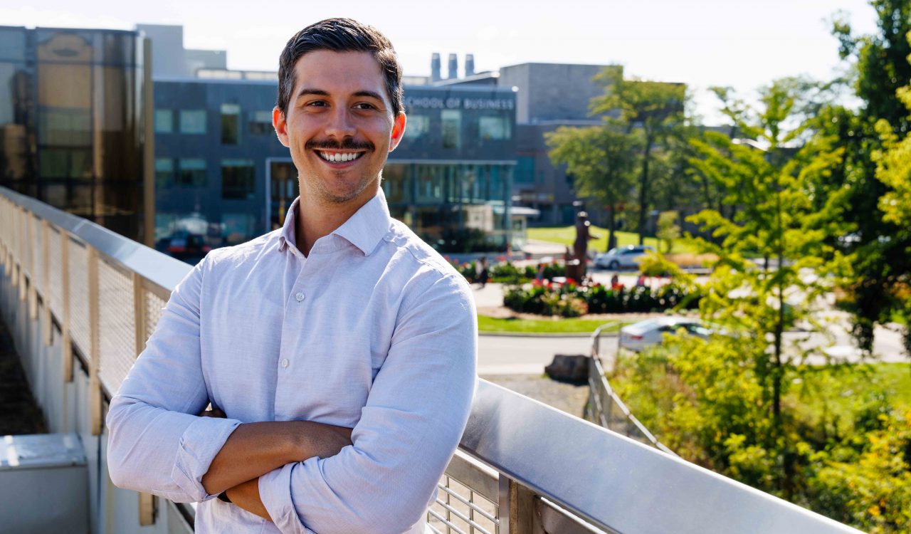 Jacob Forlin poses for a photo on a balcony overlooking the Brock University campus.