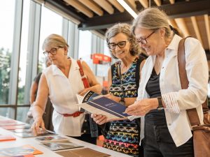 Three women look over documents from Brock University collected for a Pop-up Archive.