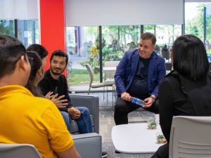 A group of people have a conversation in a university student lounge.