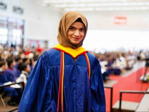 Marium Nur wears a blue convocation gown with red cords at Brock University’s Fall Convocation.