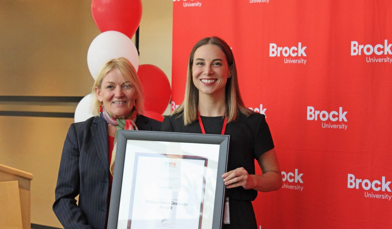 Ingrid Makus and Ornella Marinic with a framed Distinguished Faculty Graduate Award.