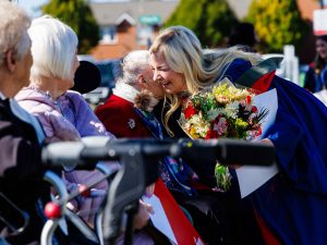 A graduate hugs a senior citizen.