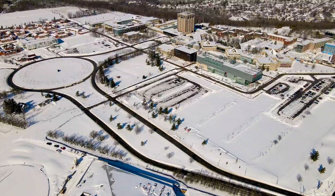 An aerial view of the Brock University campus in winter along Isaac Brock Boulevard.