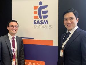 Two men, Erik Lachance and Changwook Kim, stand in front of a banner for European Association for Sport Management.