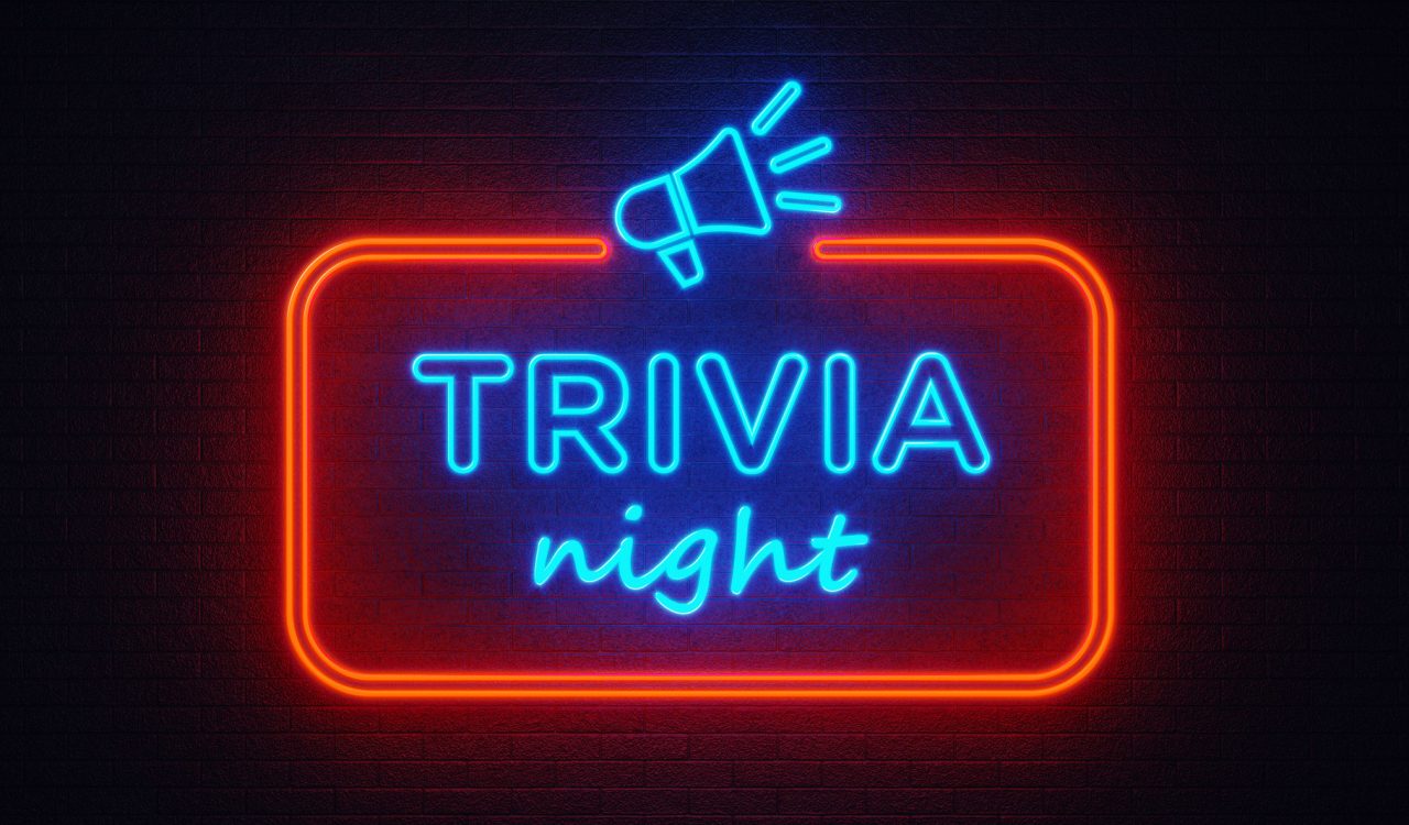 A neon sign reading "Trivia Night" hangs on a brick wall.