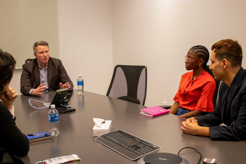 A group of people sit around a meeting table.