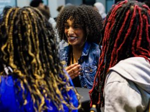 A woman laughs with her friends while seated at a table.