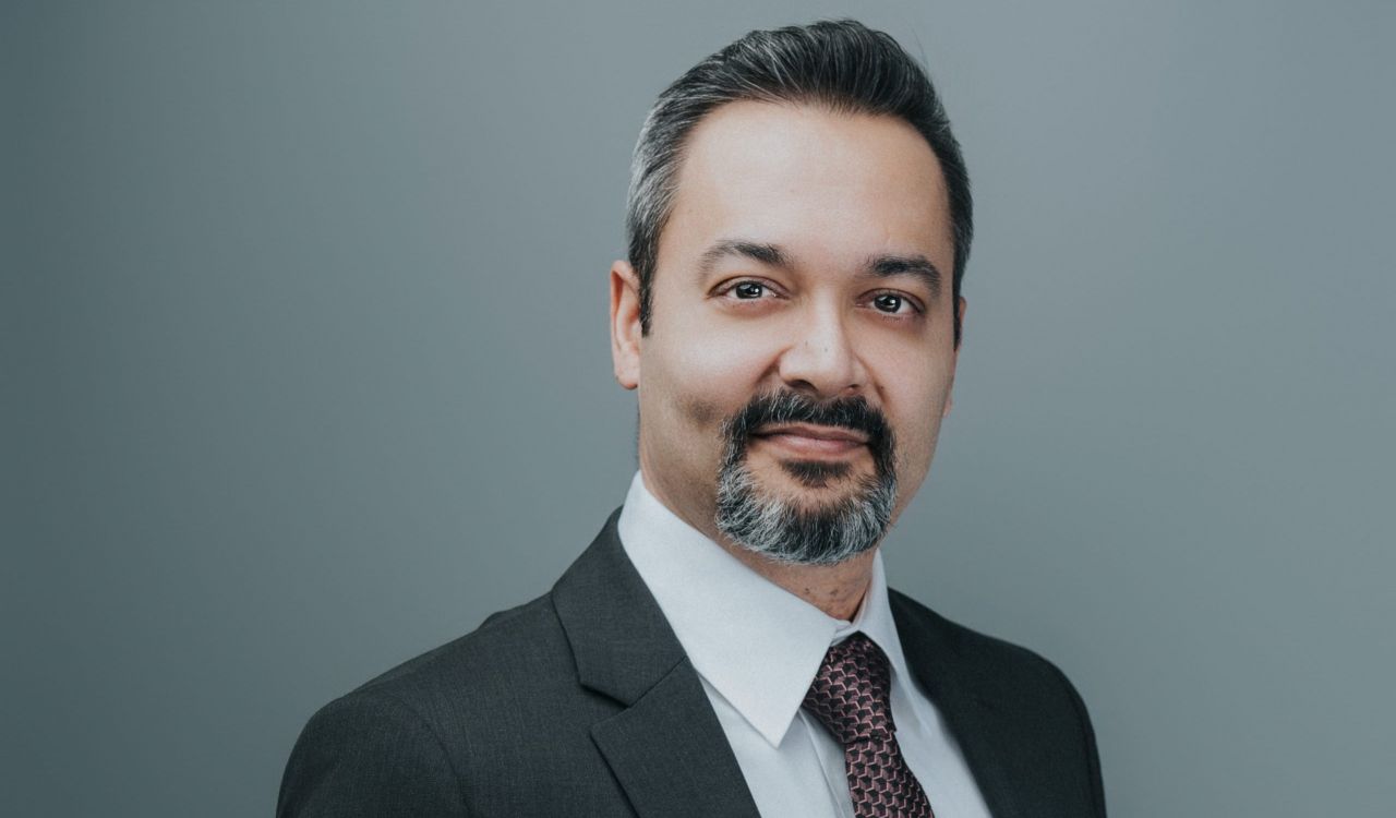 Headshot of Vice-Provost of Teaching and Learning Rajiv Jhangiani standing in front of a neutral background.