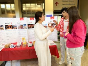 University students tasting international snacks at a fair.