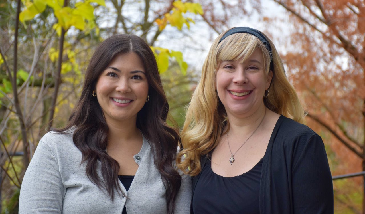 Assistant Professor Ann Farrell and Associate Professor Danielle Sirianni Molnar, with late fall foliage behind Thistle Complex at Brock University.