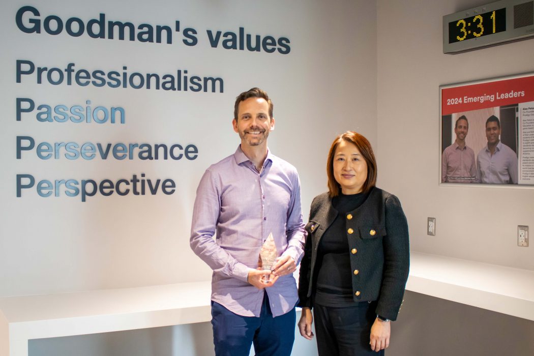 Emerging Leader award recipient, Alex Peters, holds glass plaque next to Goodman Associate Dean of Undergraduate Programs, Jennifer Li.