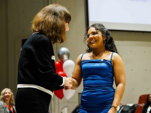 A student in Brock University’s Concurrent Bachelor of Nursing/Master of Nursing (BN/MN) program, Nianam Ramsamy, wears a blue dress while shaking hands with Professor Dawn Prentice during the University’s Pinning Ceremony on Friday, Dec. 13.