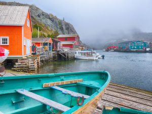 Brightly coloured boat houses of Quidi Vidi on a foggy coastline in Newfoundland.