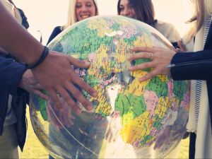 Close-up view of hands holding an inflatable globe map.