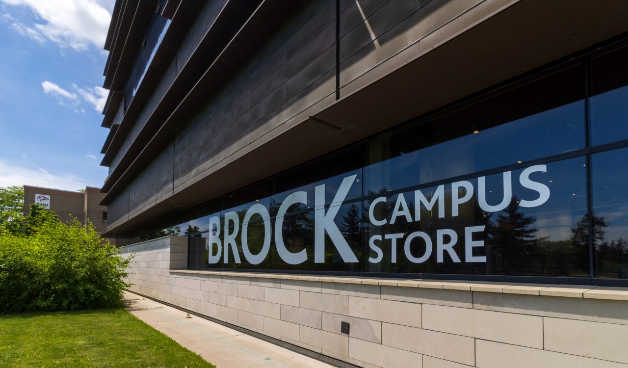 The exterior of Brock University's Campus Store with 'Brock Campus Store' written in large white letters across the building's windows.