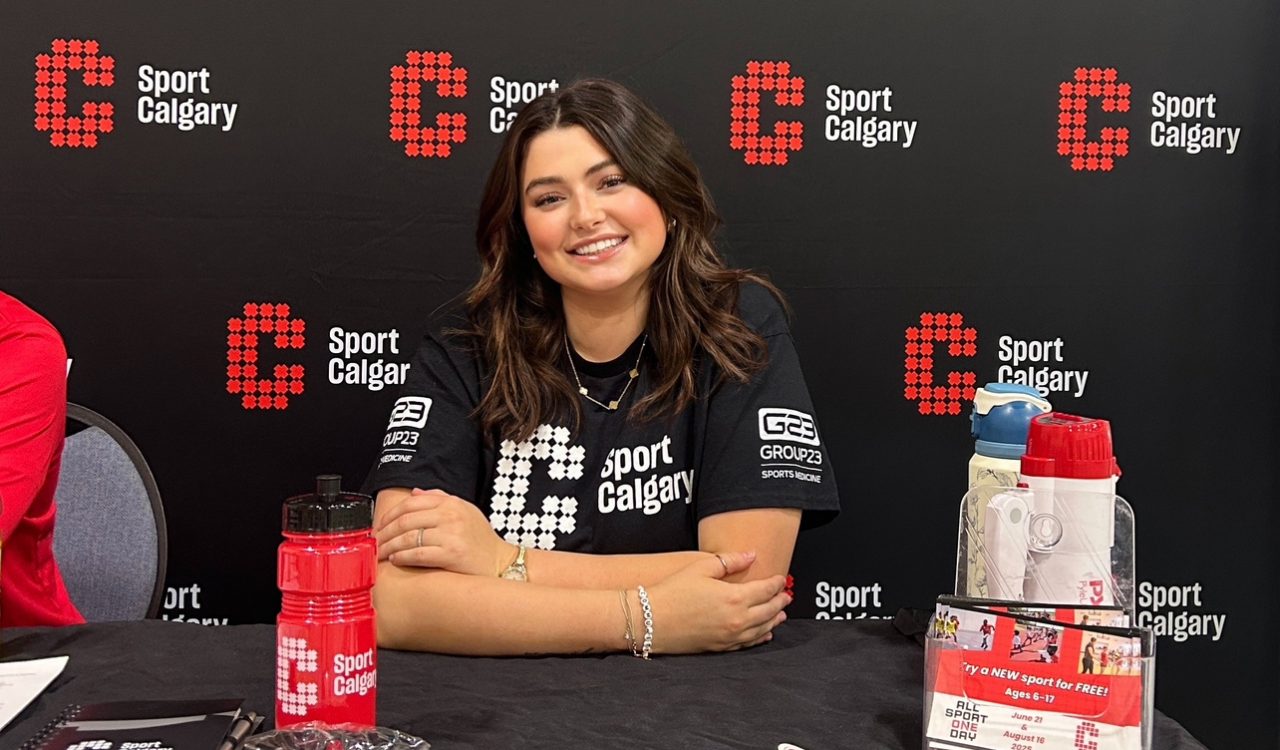 A smiling woman works at a booth during a sporting event.