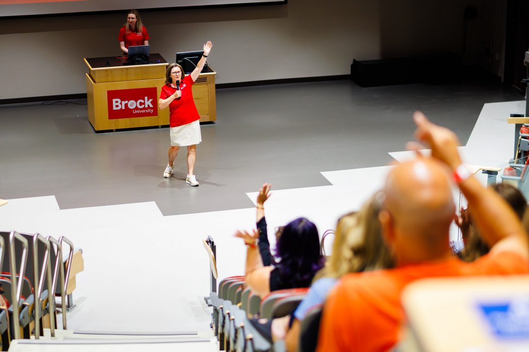 A Brock University staff member engages with attendees during a Smart Start orientation session, encouraging questions and participation from the audience.