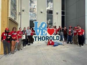 A group of university students pose for a photo with a 