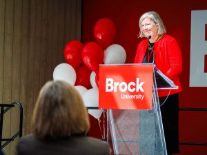 A woman speaks from a podium at a Brock University event.
