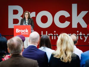 A woman speaks from a podium at a Brock University event.