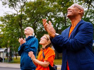 People look up and applaud during the Every Child Matters flag-raising ceremony.