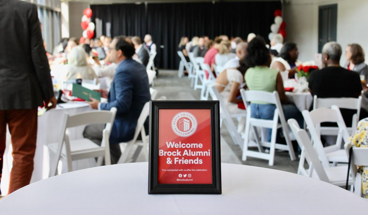 Close-up of a welcome sign on a table at an event.